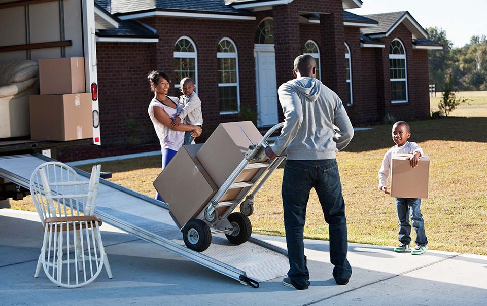 A family moving into a new home with the help of professional movers.